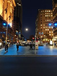 People walking on street in city at night