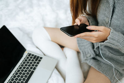 Midsection of woman using mobile phone