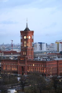 Buildings in city against cloudy sky