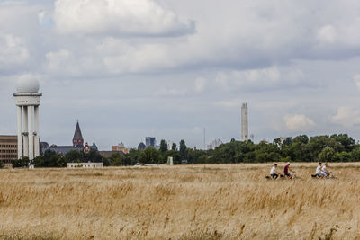 Panoramic view of people on field against sky