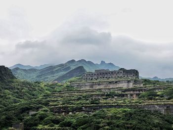 Scenic view of lost city on mountains against cloudy sky