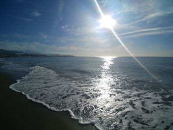 Scenic view of sea against bright sun