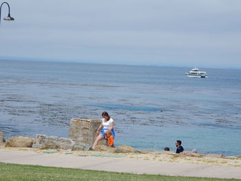 Rear view of woman sitting on beach