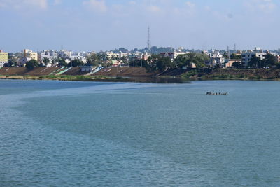 Scenic view of sea by buildings against sky