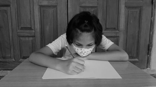 Girl writing on paper at table