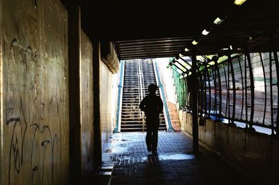 Rear view of man walking in corridor