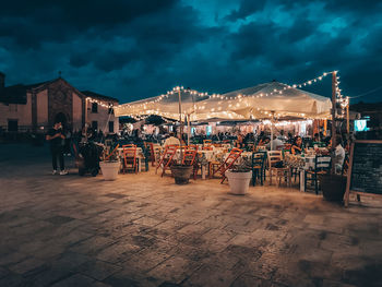Group of people at restaurant against sky at night