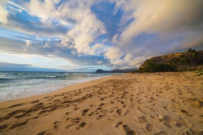 Scenic view of beach against dramatic sky