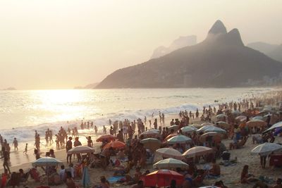 Crowd at beach by sea and mountain