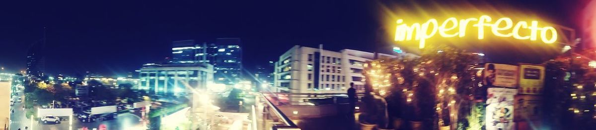 Panoramic view of illuminated city buildings at night