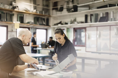 Male teacher guiding trainee on project in training class