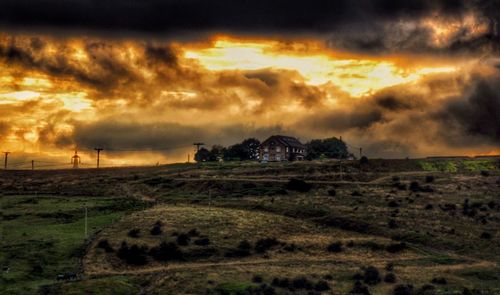 Scenic view of field against cloudy sky