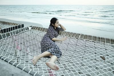 Rear view of young woman standing at beach