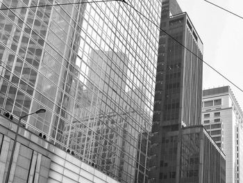 Low angle view of modern glass building against sky