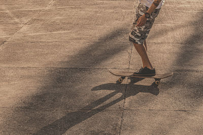 Low section of man skateboarding on road