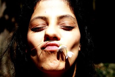 Close-up portrait of young woman with eyes closed