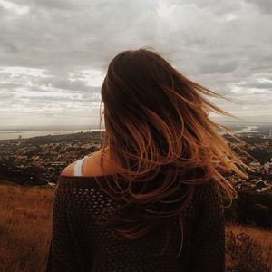 Woman looking at sea against sky