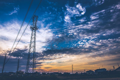 Low angle view of silhouette electricity pylon against sky during sunset