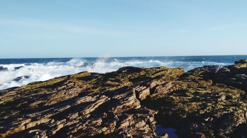 Scenic view of rock and sea against sky