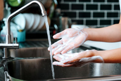 Midsection of person preparing food in kitchen