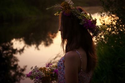 Portrait of woman standing by purple flowering plants