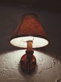 Close-up of illuminated lamp mounted on wall