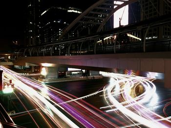 Light trails on bridge in city at night