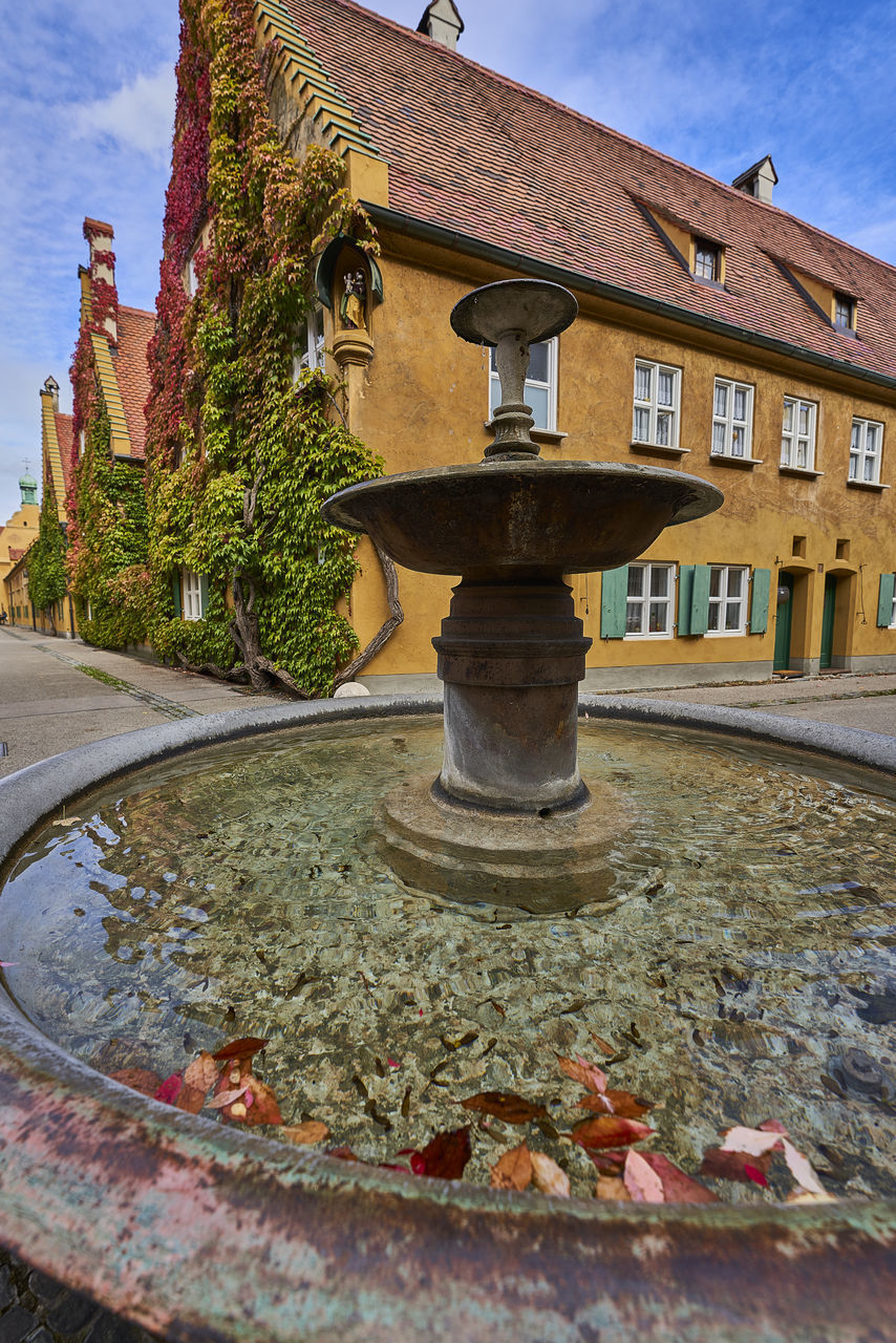 FOUNTAIN BY BUILDING AGAINST SKY