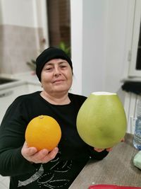 Portrait of woman holding fruits