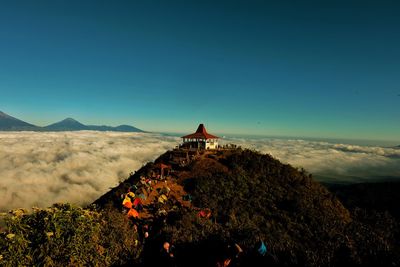 People on mountain against blue sky