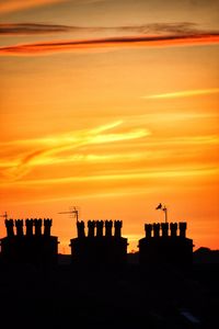 Low angle view of silhouette built structure against sky at sunset