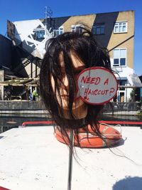 Portrait of woman with text on building in city