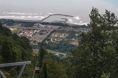 High angle view of trees by sea against city