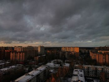 High angle view of buildings in city against storm clouds