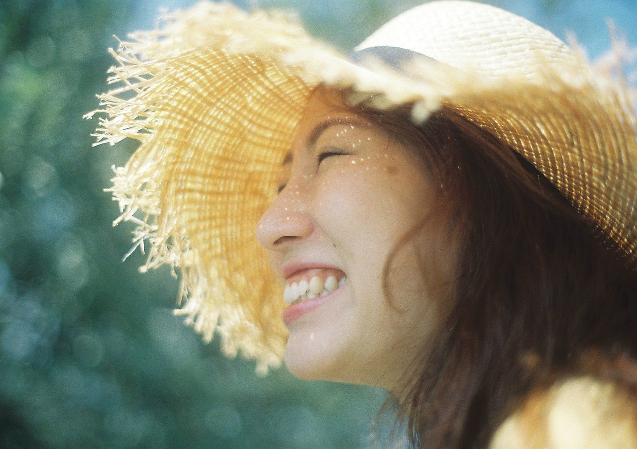 CLOSE-UP PORTRAIT OF A SMILING YOUNG WOMAN WITH HAT