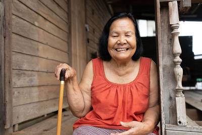 Portrait of smiling young woman sitting outdoors