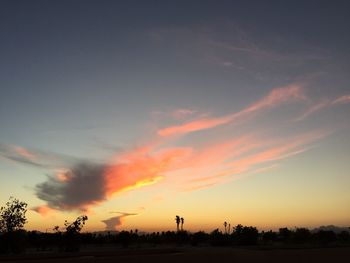 Scenic view of silhouette field against sky at sunset