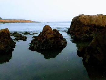 Rocks in sea against sky