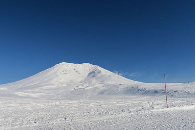 Scenic view of snowcapped mountains against clear blue sky