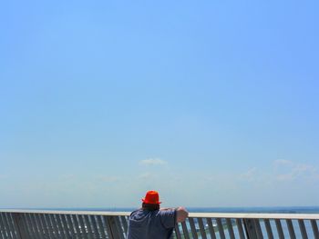 Rear view of woman standing against clear sky