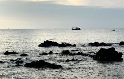 Scenic view of rocks in sea against sky