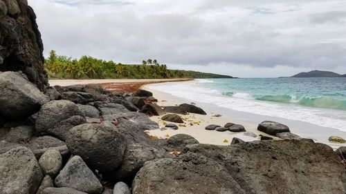Rocks on beach against sky