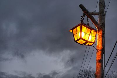 Low angle view of illuminated lamp against sky at night