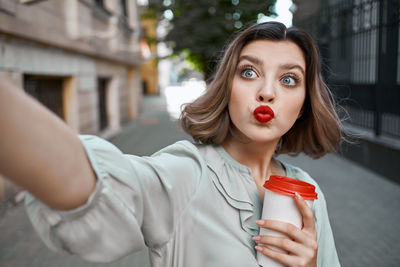 Portrait of beautiful young woman holding red outdoors