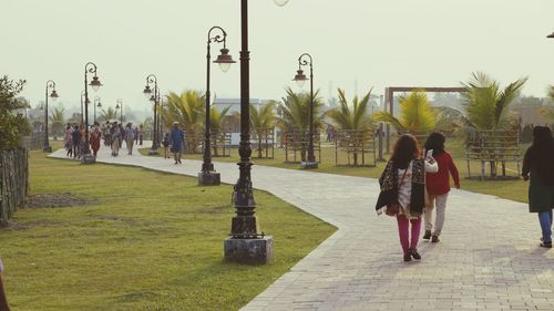 Rear view of women walking on zebra crossing