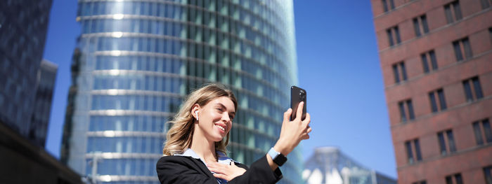 Low angle view of woman using mobile phone