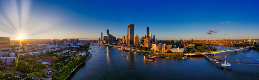 Panoramic view of river amidst buildings against sky during sunset