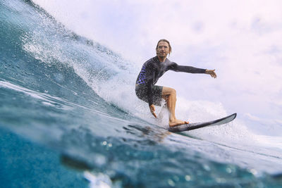 Man with surfboard surfing on sea