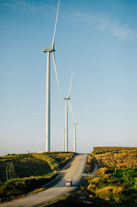 Windmill on road against clear sky