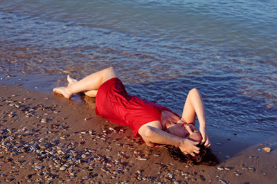 High angle view of woman lying on beach